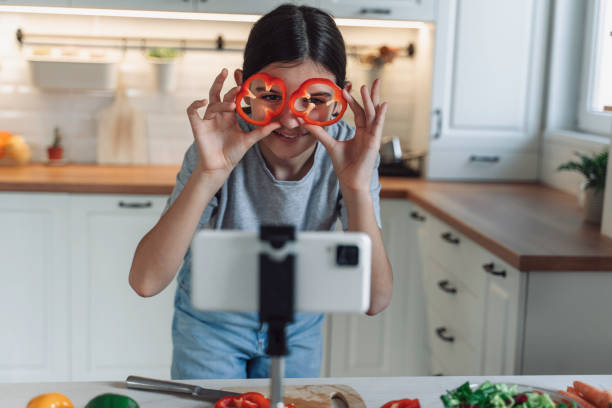 Playful girl posing with bell pepper slices during vlog