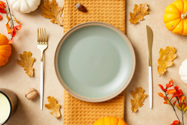 istock Autumn table setting with pumpkins, leaves, and an empty plate with cutlery. Thanksgiving, seasonal dining, fall holiday celebration concept. 2175733192
