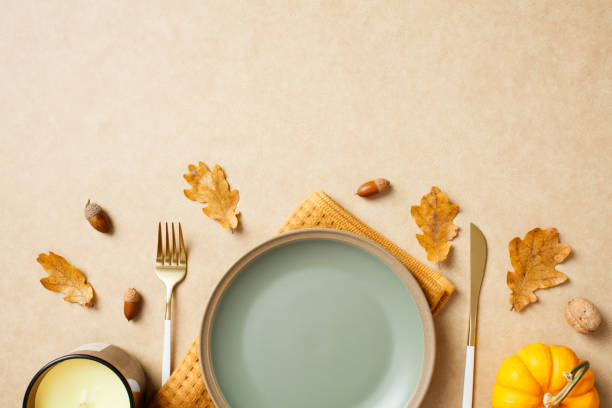 istock Thanksgiving table setting with oak leaves, acorns, walnut, candle, and a small pumpkin. Autumn, fall dinner concept. 2175733556