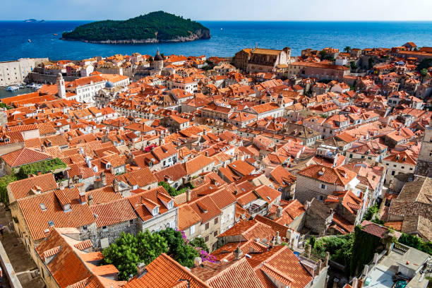 Beautiful view with picturesque red roofs of Dubrovnik old town and marina with boats, Croatia.