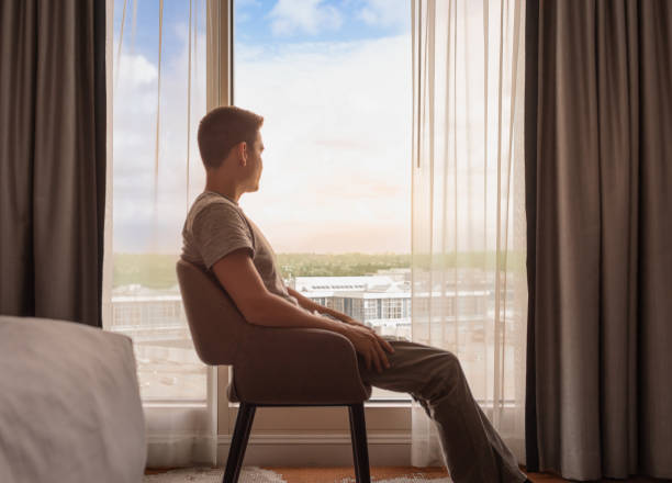 istock Thoughtful happy relaxed content man at home looking out his window at the view. 2175758183