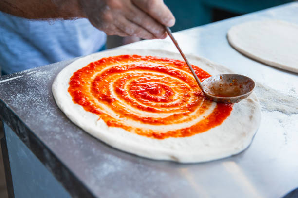 istock Pizza chef spreading tomato sauce on the pizza 2175763057