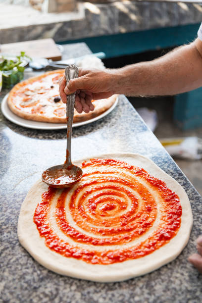 istock Pizza chef spreading tomato sauce on the pizza 2175763518
