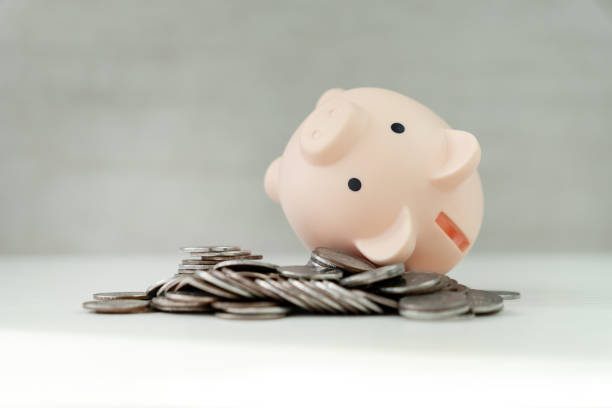 istock inverted piggy bank on silver coins on white background on white table 2175763841