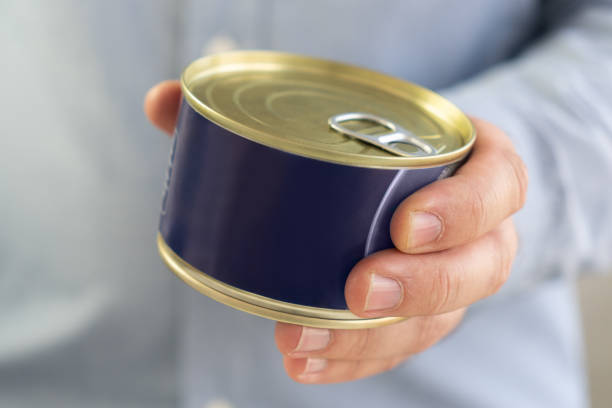 istock Hand holds canned food on white, man hands. empty label for design and text. Copy Space 2175763902
