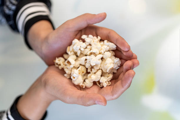 istock Close up image of a girl holding and picking pop corn 2175764166