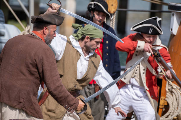Dana Point, CA, USA - September 15, 2024: Ships crew point their weapons at pirates in a historical reenactment during the Ocean Institute’s 40th annual Maritime Festival held in Dana Point Marina.