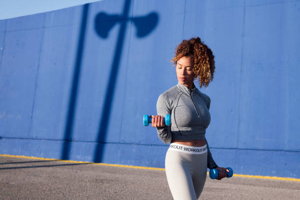 istock latin female athlete working out with dumbbells 2175766387
