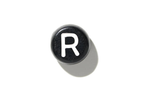 Vintage black typewriter key with r letter casting a shadow on a white background for minimalist design concepts