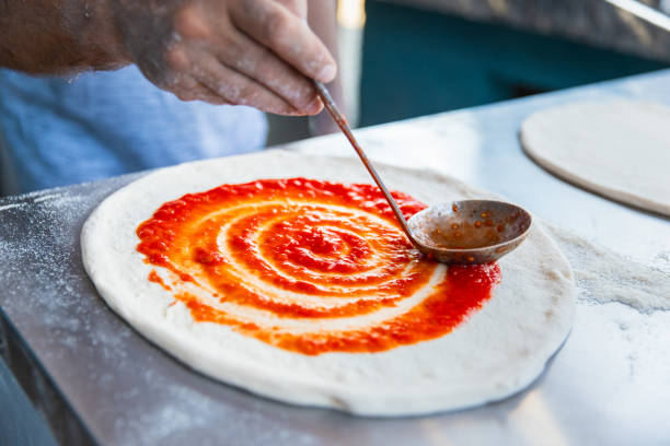 istock Pizza chef spreading tomato sauce on the pizza 2175769842