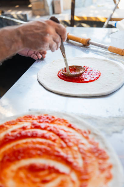 istock Pizza chef spreading tomato sauce on the pizza 2175769892