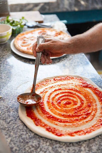 istock Pizza chef spreading tomato sauce on the pizza 2175770771