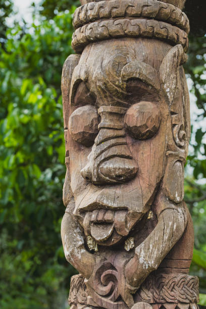 Balikpapan, Indonesia - September 29th, 2024. A close-up of a weathered Dayak tribe wooden totem pole featuring a detailed carved face with big eyes and big nose.