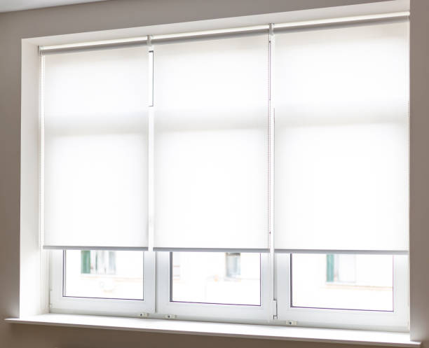 istock Modern white roller shades covering windows in a bright room during daylight hours 2175781067