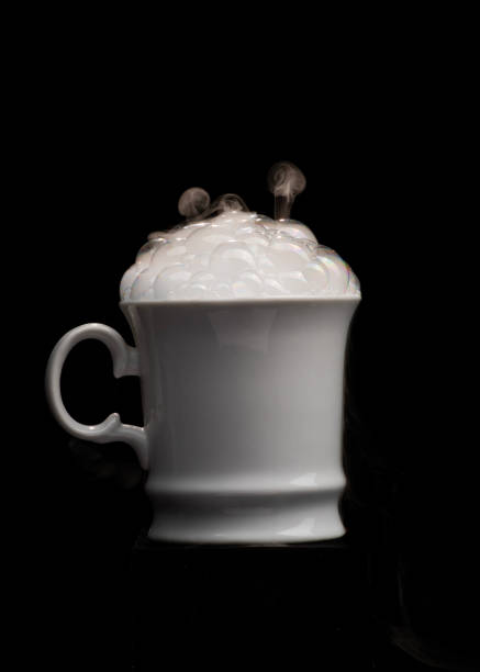 a black coffee poured into a porcelain coffee pair on a black background