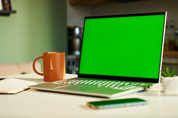 istock Laptop with green screen display on desk in kitchen at home. Remote workplace 2175802685
