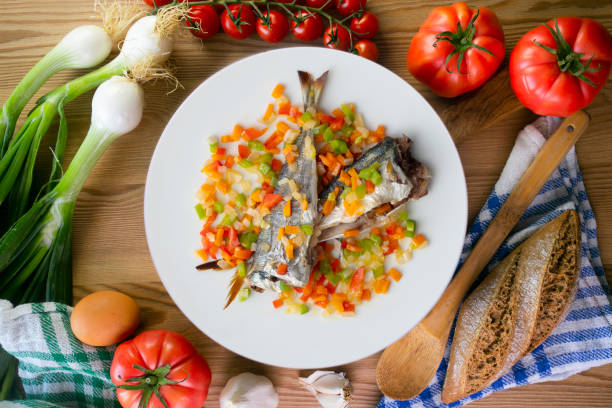 Baked horse mackerel with chopped vegetables. Top view table with  decorations..