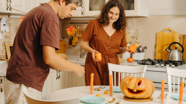 istock A middle-aged couple sets the table for the Halloween party 2175817637