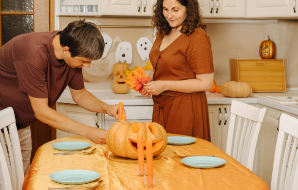 istock Middle-aged couple sets the table for Halloween party 2175817654