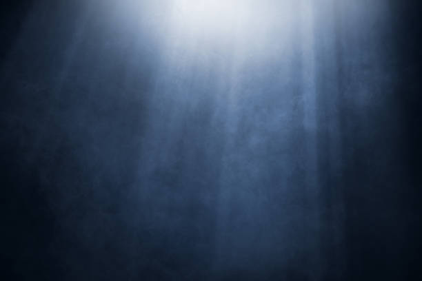 istock White and blue light rays with smoke against black background 2175820501