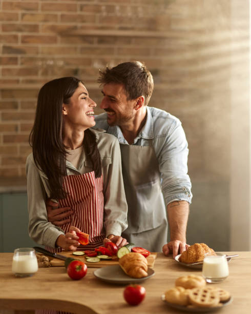 istock Happy couple in love talking while preparing meal in the kitchen. 2175820592