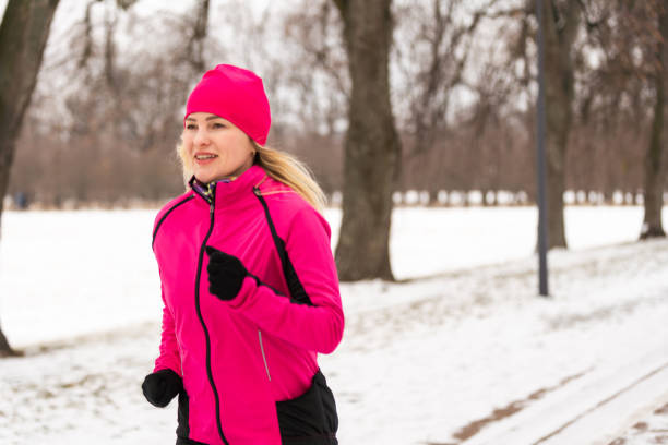 Sportive young woman running in winter morning. High quality photo