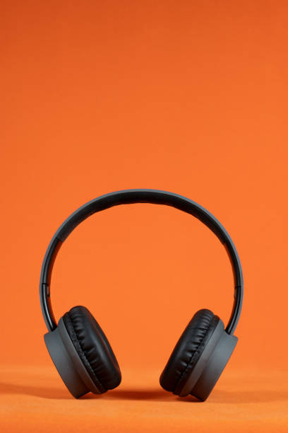 istock Black headphones positioned against a bright orange background 2175822038