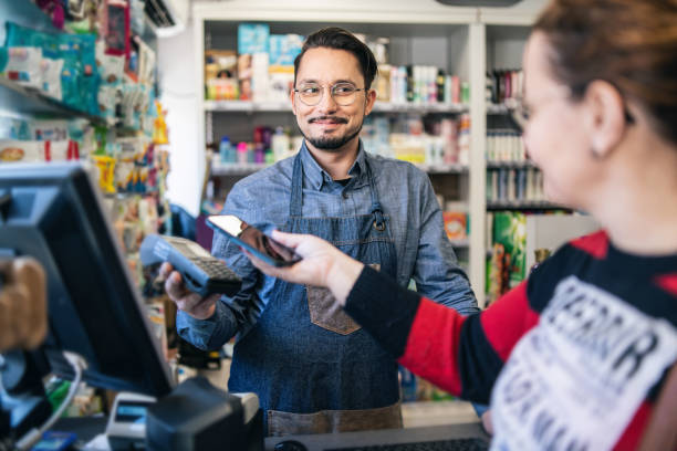 istock Customer paying  at supermarket using his smartphone 2175825573
