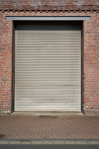 istock Old rolling garage door and brick wall 2175828237