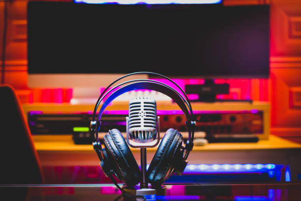 Close up instruments music background concept.Headphones hang  on microphone with sound mixer board in home recording studio.Free space for creative design text & wording mock up template wallpaper.