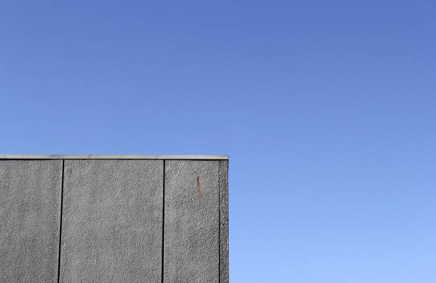 istock Concrete building wall against a clear blue sky background textured abstract 2175830359