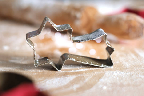 Close up Christmas cookies mold flying star and flour.