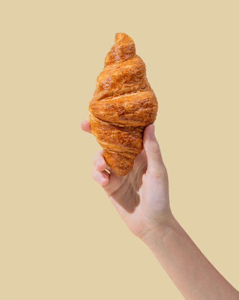 istock Hand hold fresh croissant on a yellow background. 2175833992
