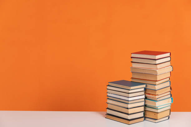 istock Stacks of educational books for library learning as an orange background 2175837289