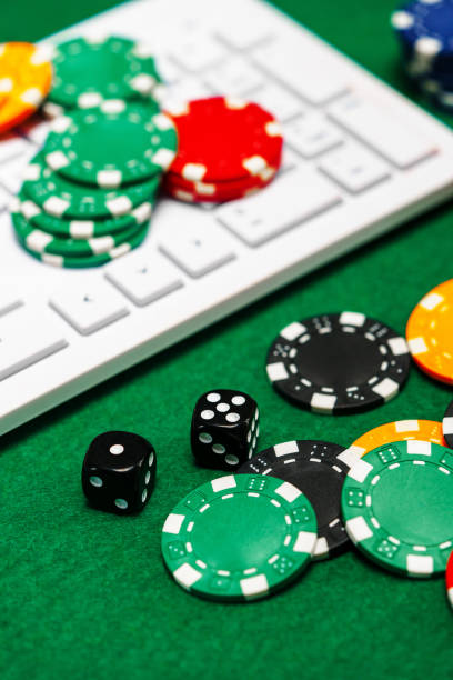 istock Chips and playing cards on a green felt surface near a computer keyboard during an online gaming session at home 2175837716