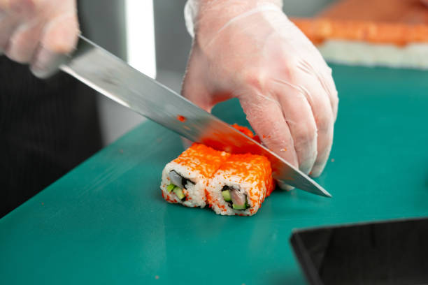 istock Sushi chef skillfully slicing fresh sushi rolls with precision at a bustling restaurant kitchen 2175838820