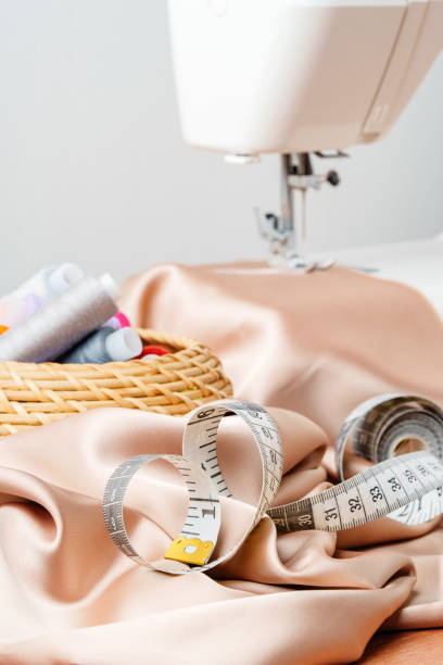 istock A sewing machine on a wooden table with fabric and thread organized in a basket 2175839235