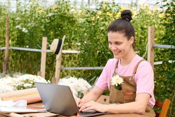 istock Smiling Woman Using computer in Flower Plantation 2175839299