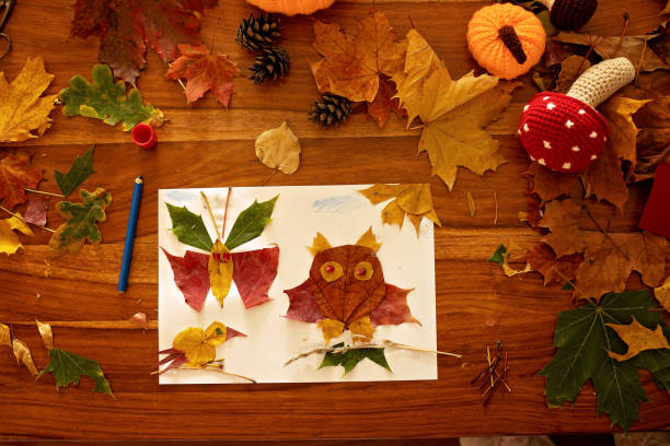 istock Child, applying leaves using glue, scissors, and paint, while doing arts and crafts at home 2175844773