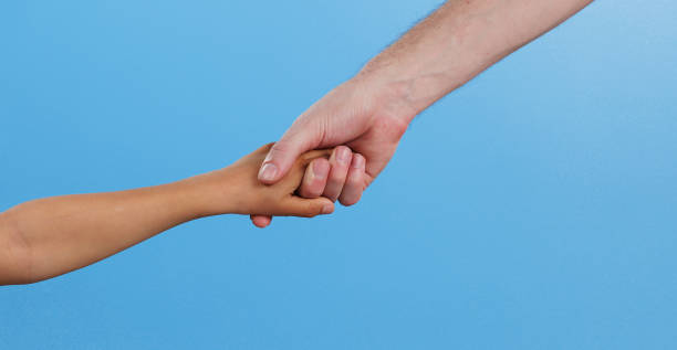 istock People, arms and holding hands with support in studio for teamwork, connection and collaboration. Friends, love and emoji with gesture of unity for solidarity, care and kindness on blue background 2175844813