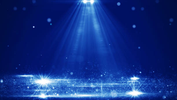 Blue stage scene illuminated with bright spotlights with shiny abstract particles floating in the air. Effect on dark blue background.