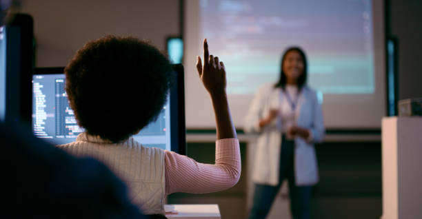 istock Multi Ethnic Group of Students Engaged in STEM at Coding Lecture with Instructor and Raising Hands 2175850122