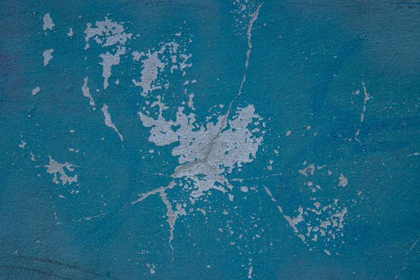 Peeling paint and cracked blue wall texture background. Weathered decayed urban surface with chipped paint and cracks. Distressed, rustic aesthetic for graphic design, web design, digital art.