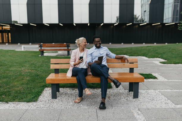 istock Cheerful duo sitting on bench, enjoying outdoor time 2175850599