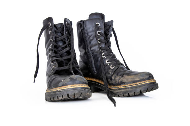 istock Pair of rugged worn black ankle leather combat boots with  thick, sturdy soles and laces. Two vintage military style shoes. Studio light. Isolated on white background. Empty copy space. Clipping path 2175850745