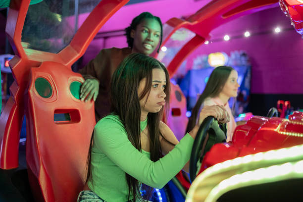 istock Friends Experiencing Ups and Downs While Playing Arcade Racing Game. Group of young friends reacting with different emotions during an intense arcade racing game, with one player showing frustration. 2175857766