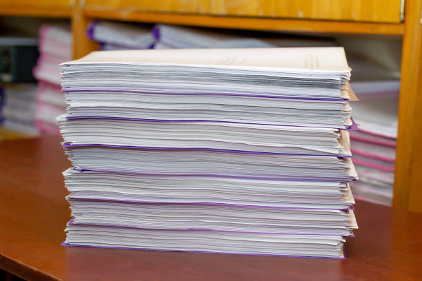 istock pile of documents on a wooden table. paperwork. data archive. office work 2175859494