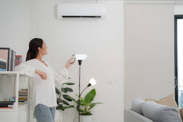 istock Young woman controlling smart air conditioning system at home 2175859661