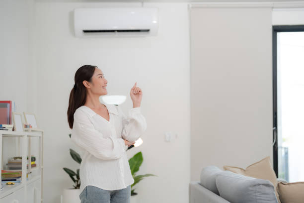 istock Smiling young woman with pointing gesture indoors 2175859675