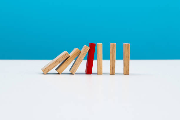 istock Red wooden block stop other falling dominos 2175870543